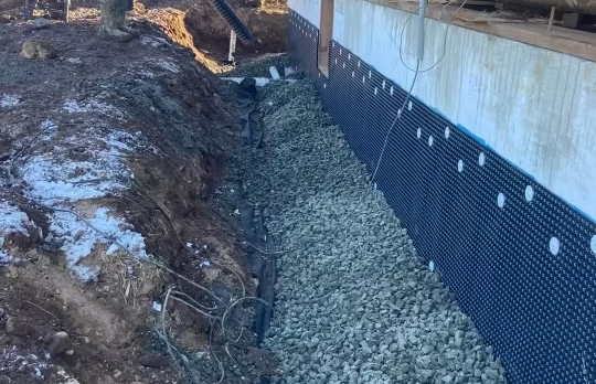 Exterior foundation waterproofing work in progress.